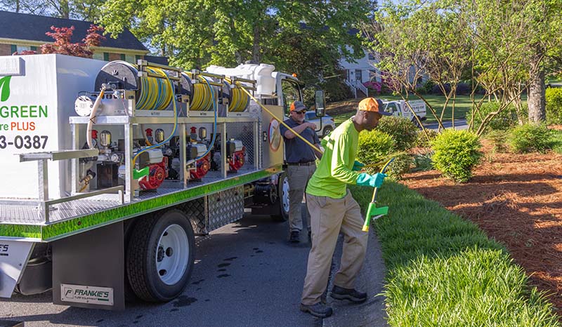 A Photo of a Simply Green Lawn Care Service Manager Unwinding a Sprayer